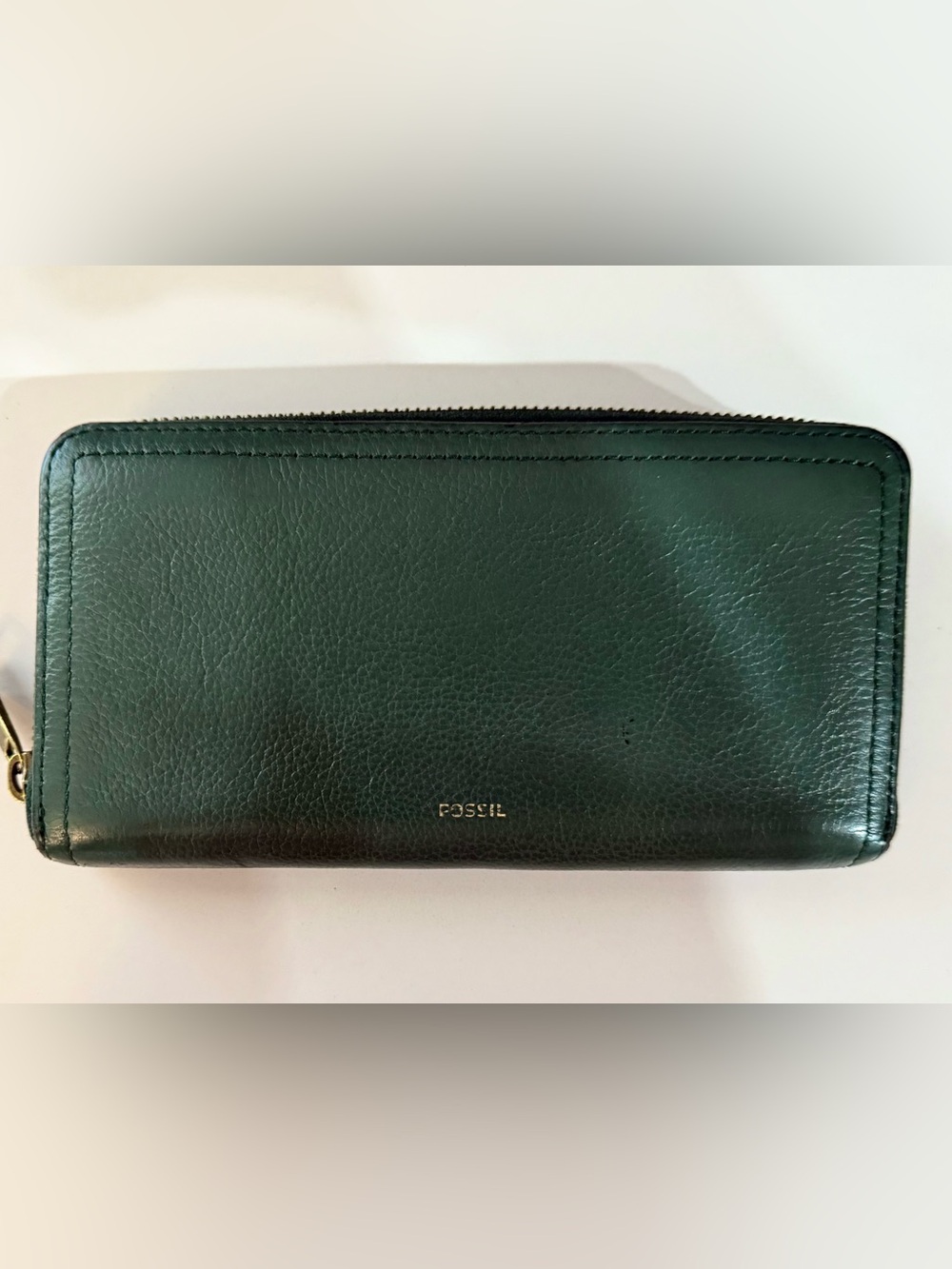 Fossil green leather wallet. Gold embossed logo, several pockets. Zip close.